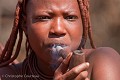 Jeune femme Himba fumant sa pipe. Kaokoland. Namibie. Africa 
 Afrique 
 Afrique Australe 
 Himba 
 Kaokoland 
 Namibia 
 Namibie 
 Southern Africa 
 people 
 peuple 
 tribe ,
Himba,
Lady,
femme,
lady,
fumer,
smoke,
Namibia,
Kaokoland,
 